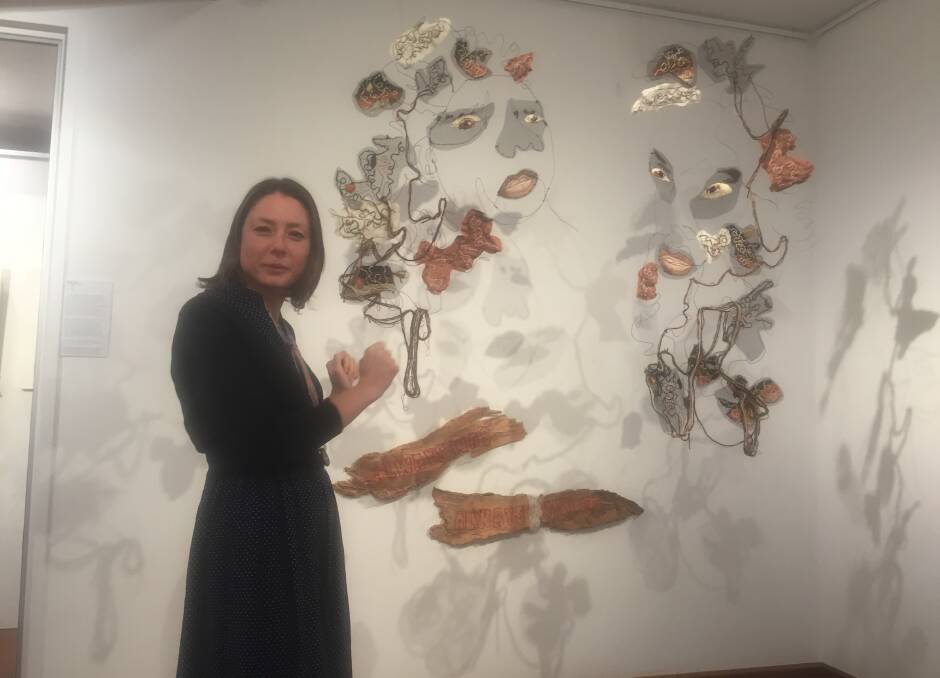 STUNNING: Shoalhaven Regional Gallery gallery officer, Bridget MacLeod with Brigitte Sharpe, of Kiama High School's work, First People, 2020. This work won the 2021 Shoalhaven Art Society Award for Excellence.