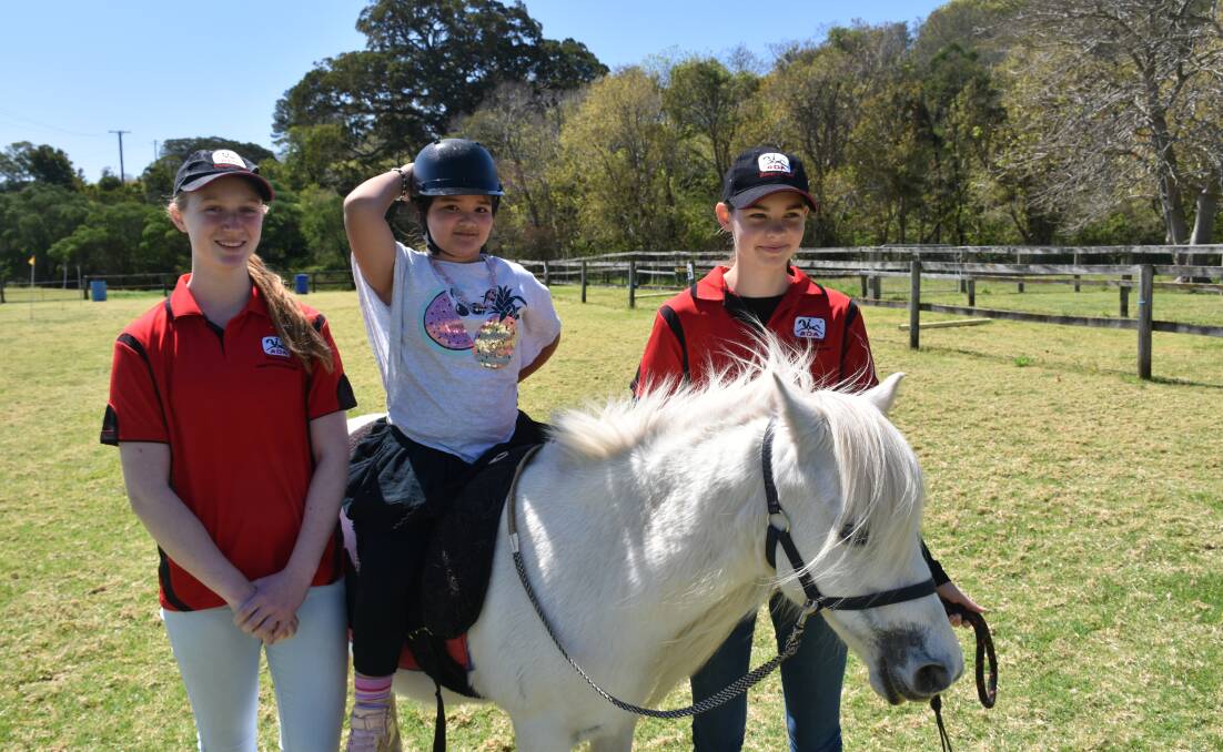 RDA volunteers Ariel (left) and Milly with Akira, 7, on Chloe.