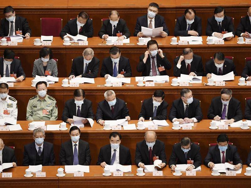 National People's Congress delegates wear face masks at the Great Hall of the People in Beijing.
