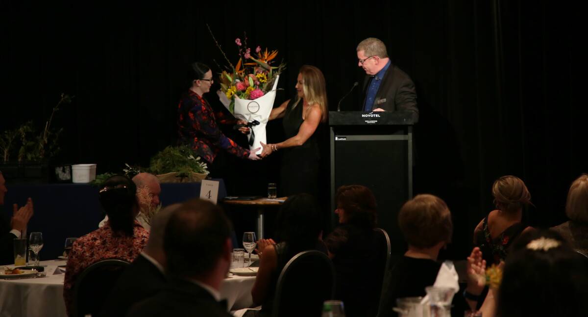 Thank you: Suzi Albert receives flowers from Sharon Wingate and TIC president Graham Lancaster at the Novotel Wollongong Northbeach. Pictures: Greg Ellis. 