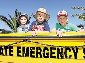Kiama boys Hamish, 3, Liam, 5, and Kade Ovenden, in the SES boat. Picture: Dylan Robinson